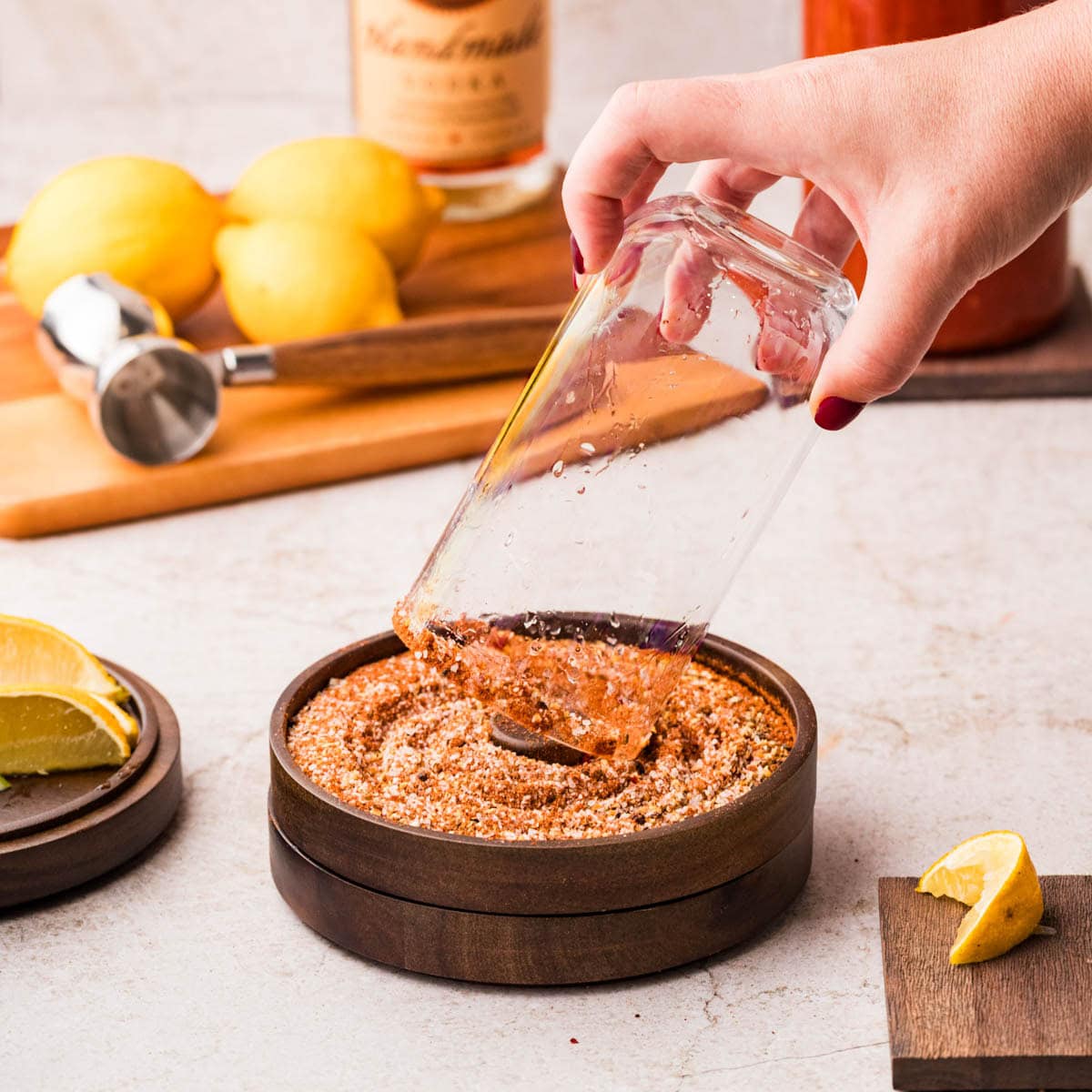 Dipping a glass into bloody mary rim salt.
