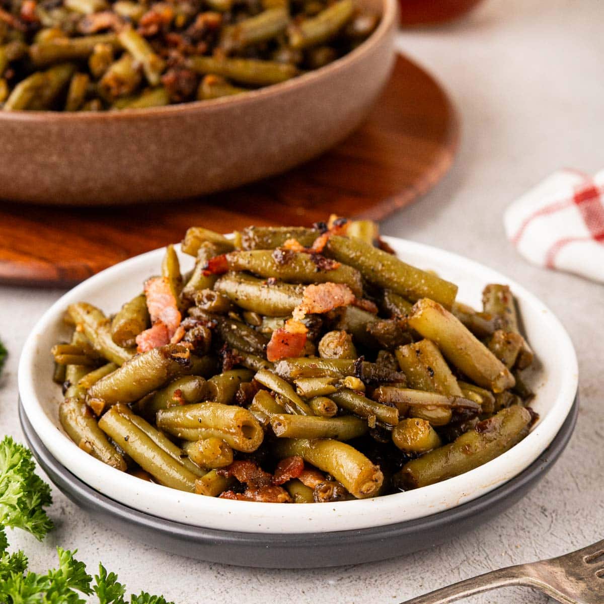 Crack green beans served in a shallow bowl with more in a bowl in the background.