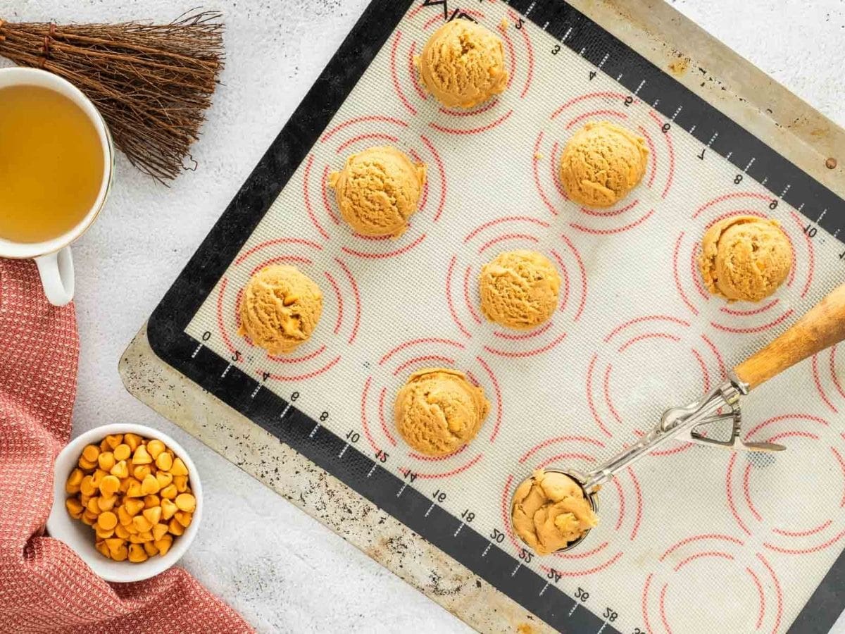 Using a cookie scoop to place the butterbeer cookie dough on a sheet pan.