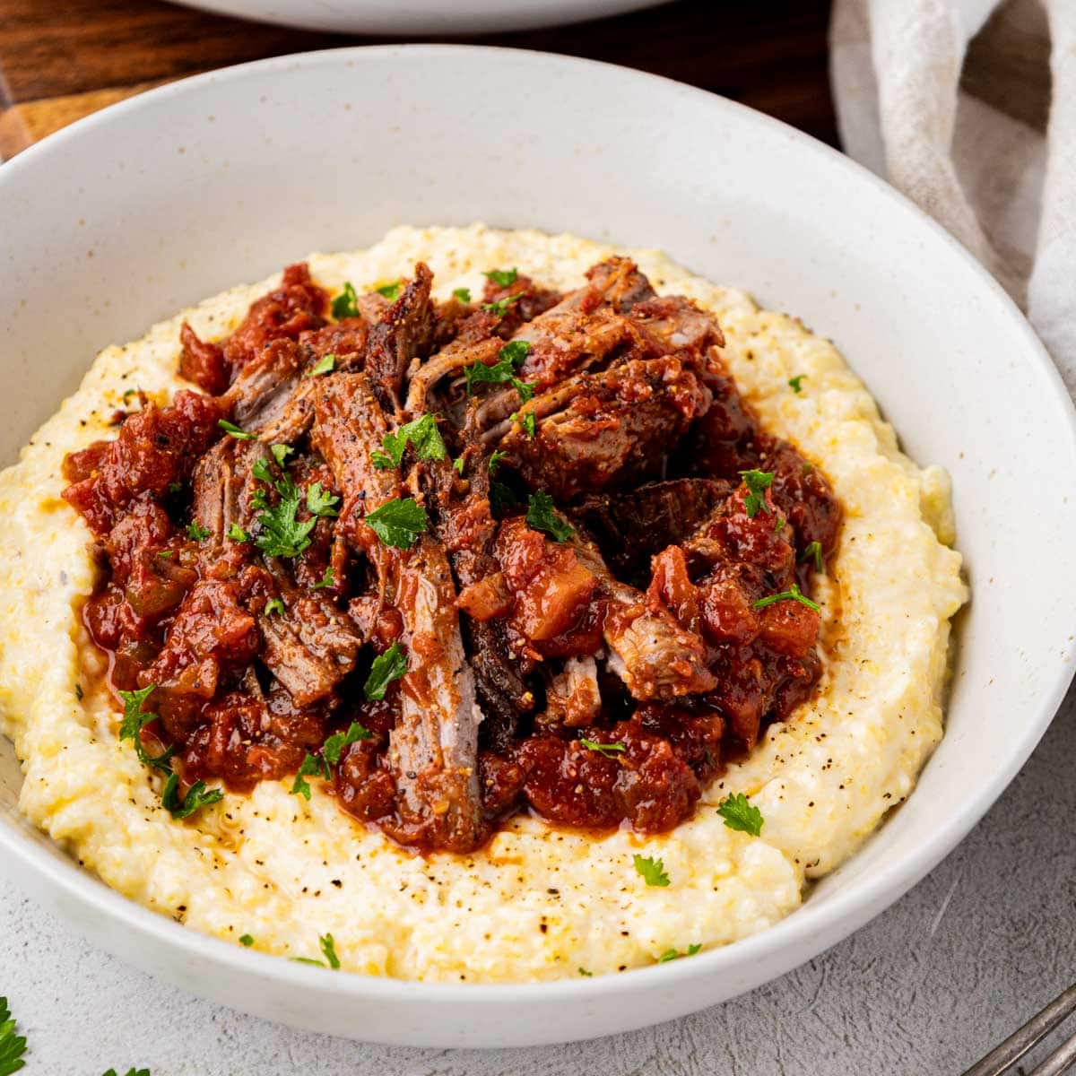 Stracotto Italian pot roast served on a bed of polenta.