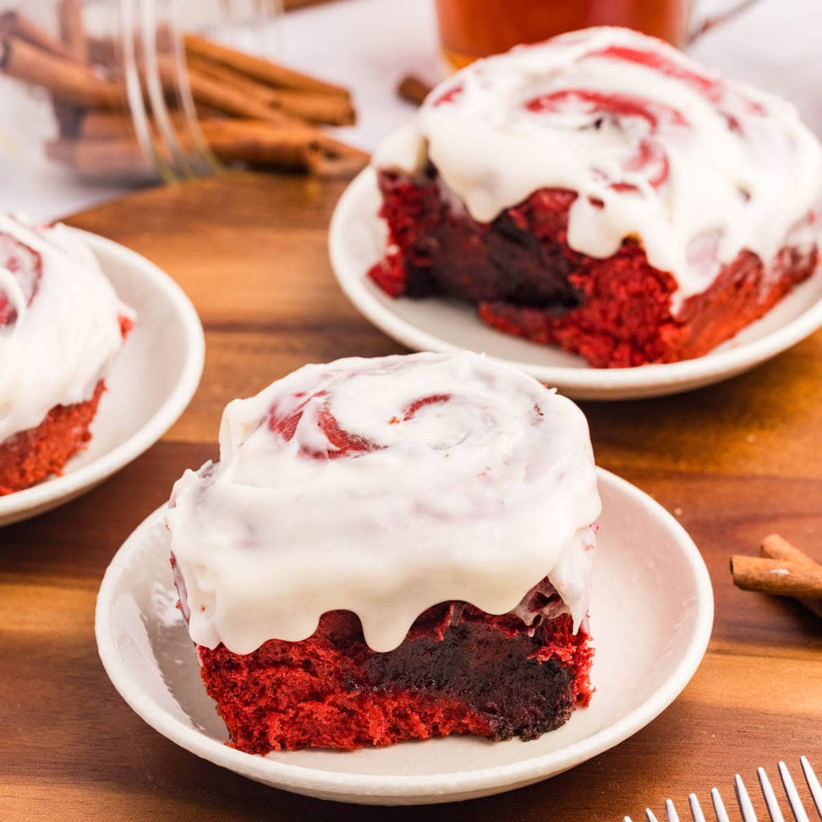 Gooey red velvet cinnamon roll center on a white plate.