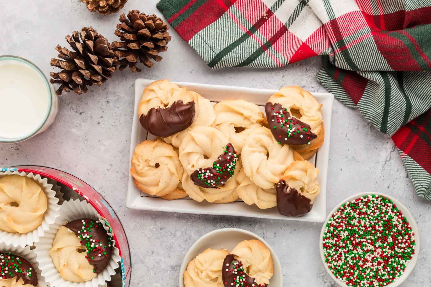 Danish butter cookies on a serving platter with some of them dipped in chocolate.