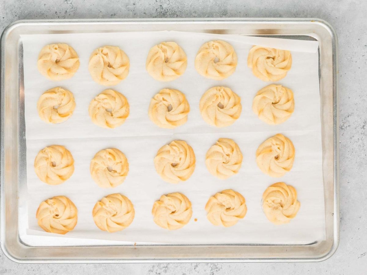Baked danish butter cookies on a sheet pan.