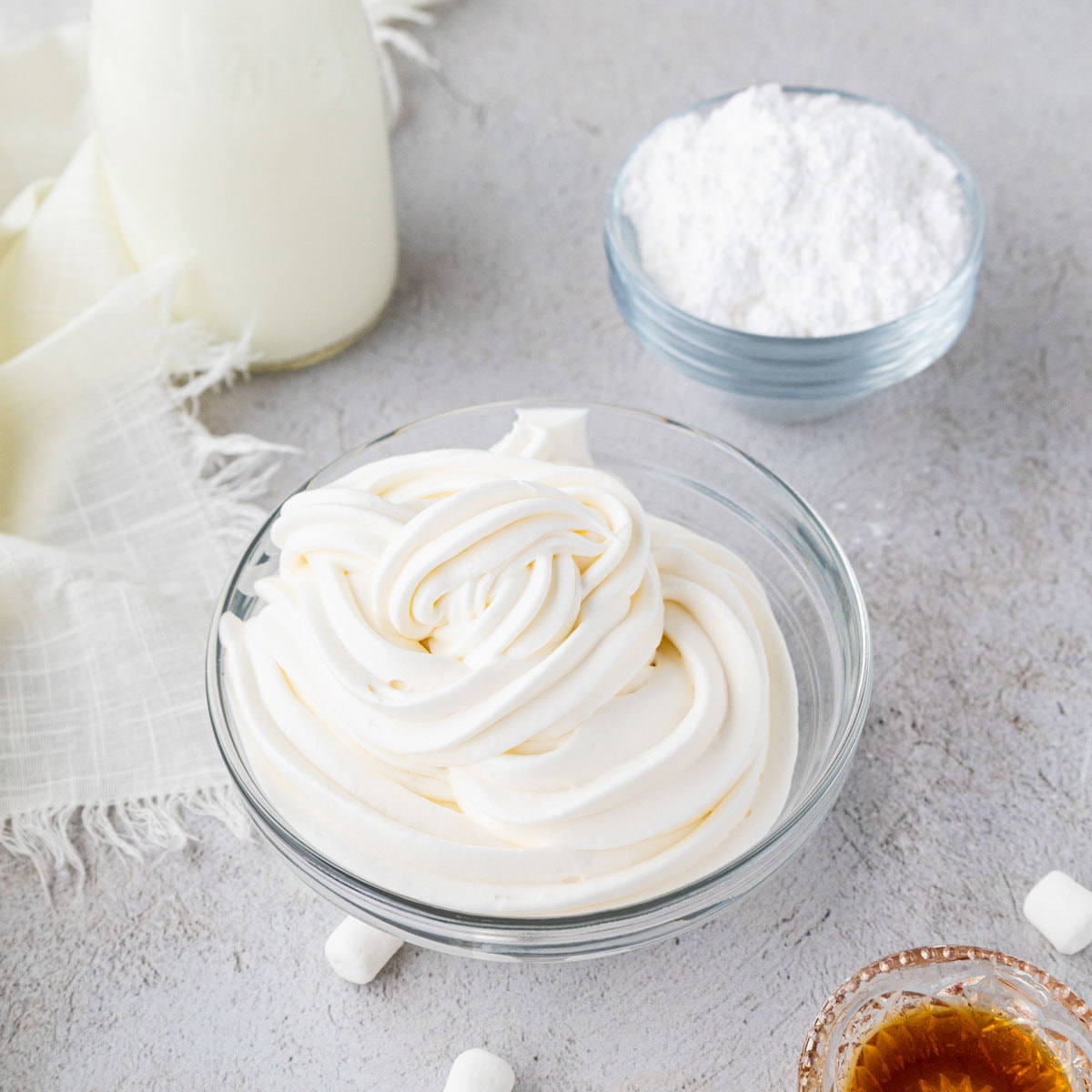 Marshmallow whipped cream piped into a glass bowl.