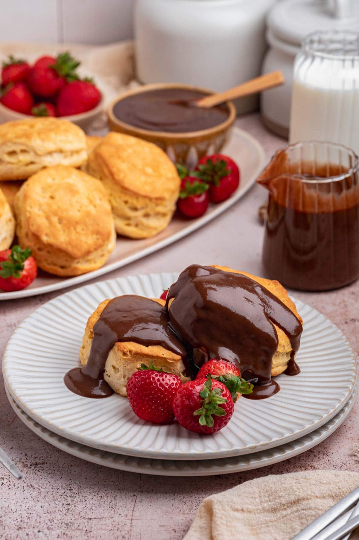 Two biscuits on a plate with chocolate gravy poured over the top.