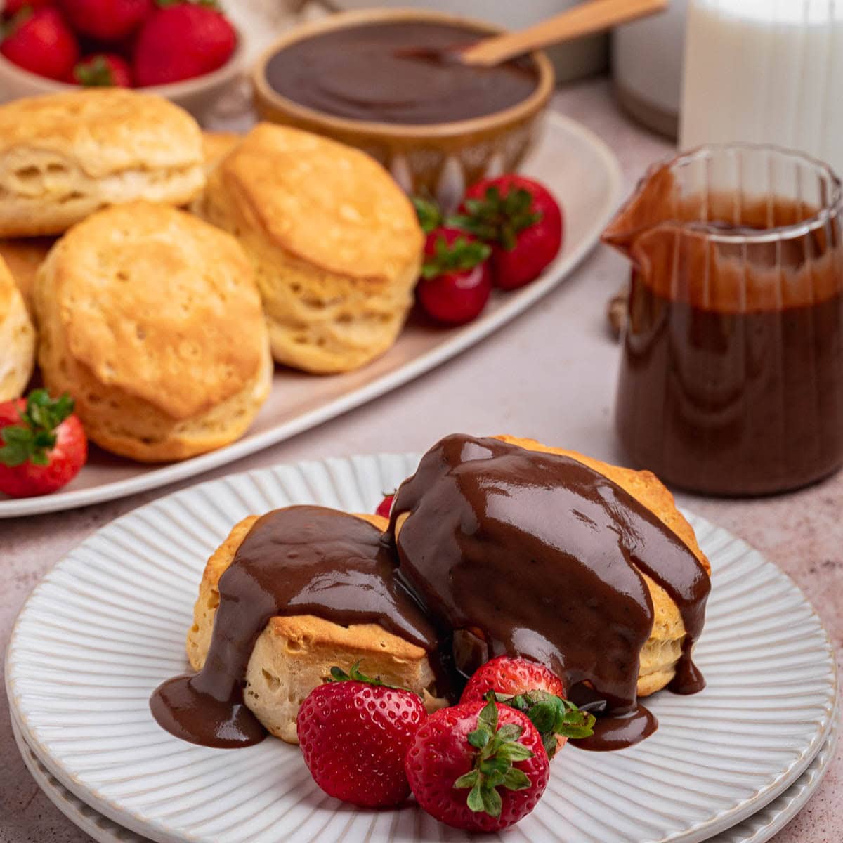 Close up of two biscuits on a plate with chocolate gravy over the top.