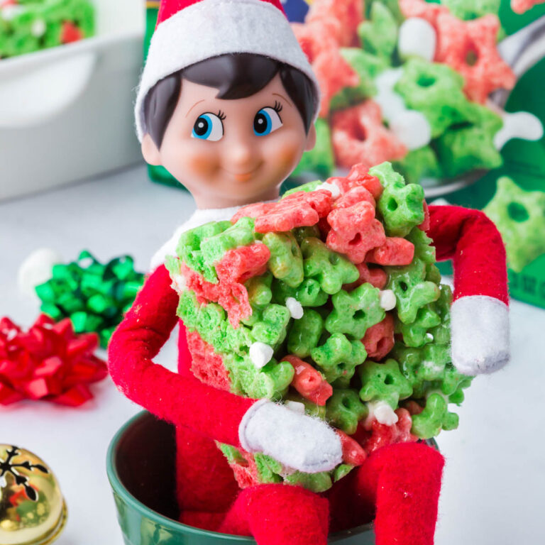 An Elf on a Shelf holding an elf on the shelf cereal bar.