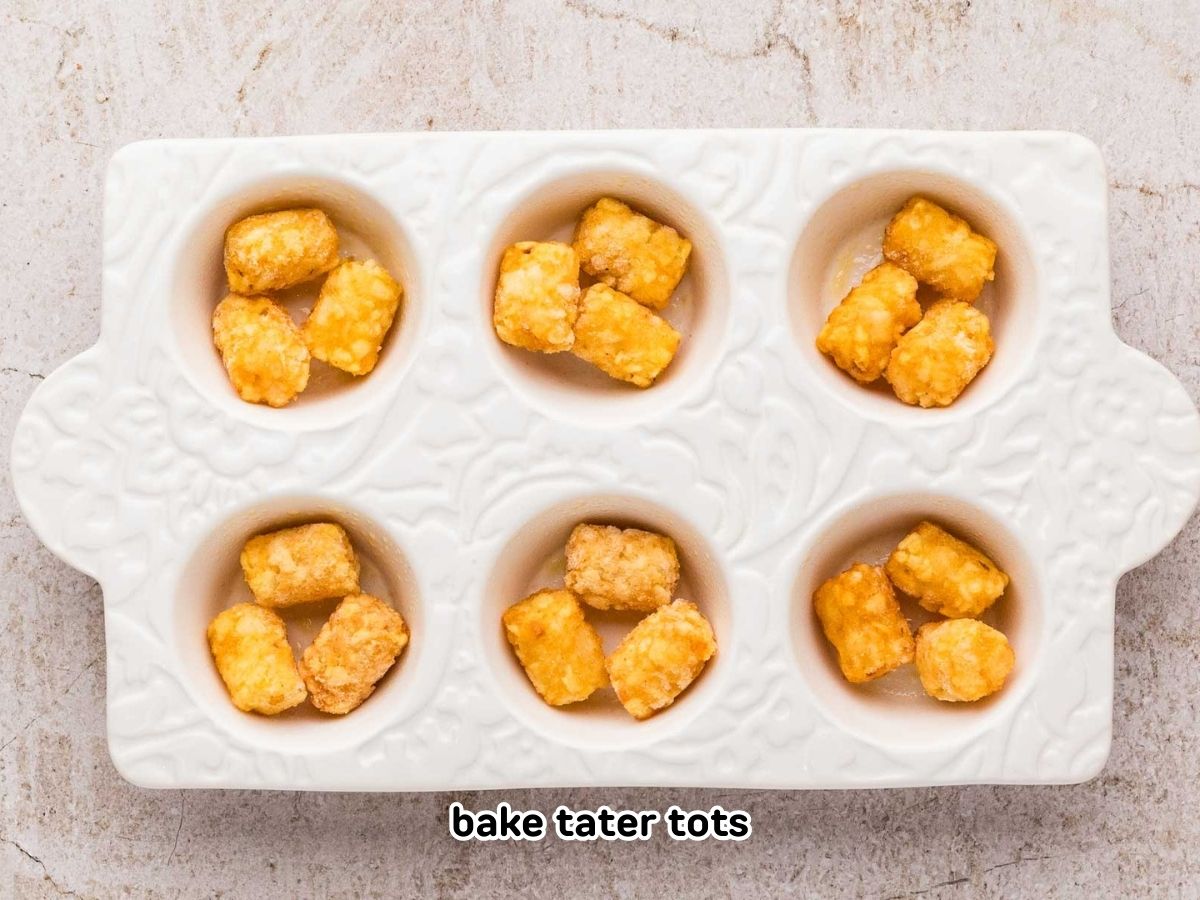 Three tater tots in each of the muffin cups in a muffin tin.
