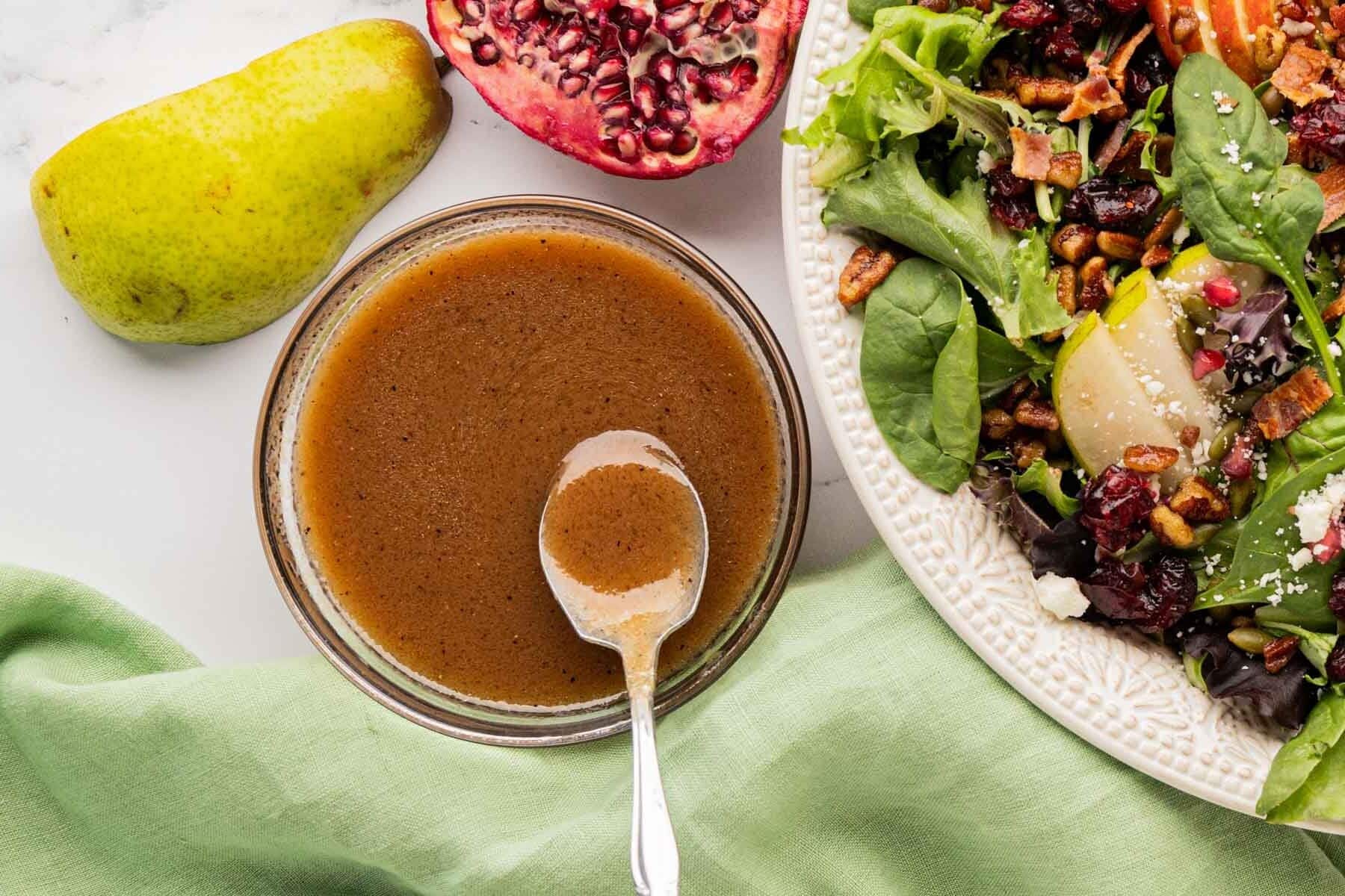 A spoon removing a serving of apple vinaigrette.