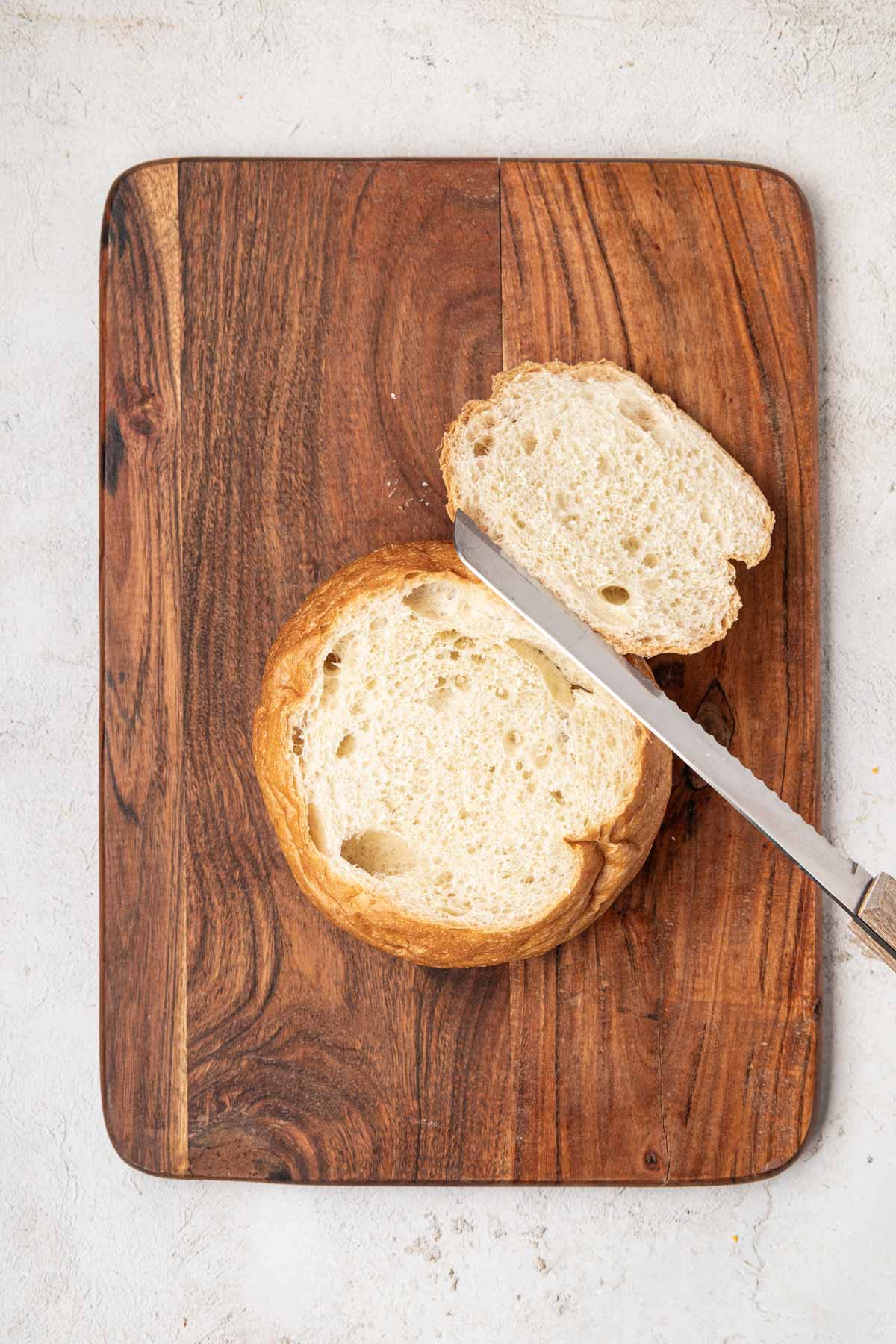 Cutting the top of bread with a knife.