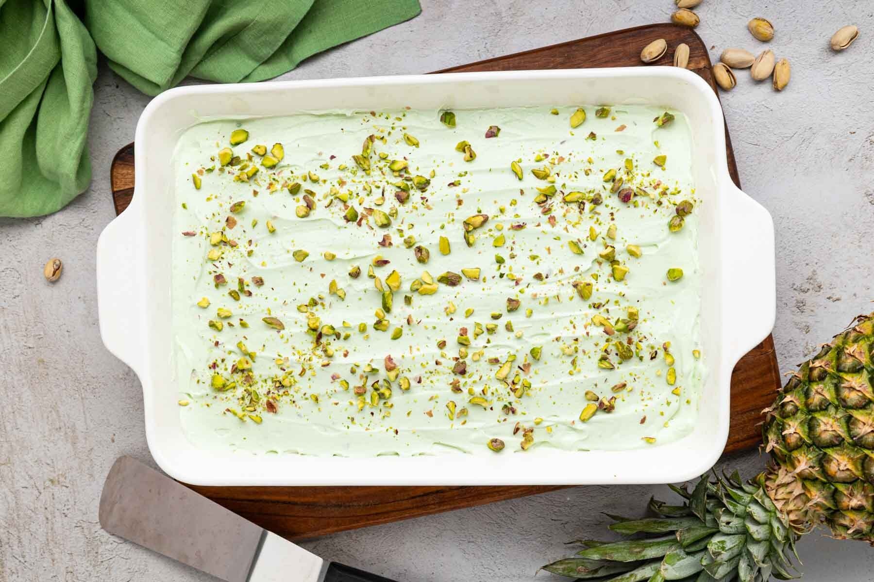 Overhead shot of finished pistachio pineapple cake with crushed pistachios on top.