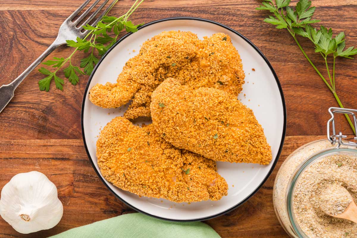 Cooked shake and baked chicken cutlets on a white plate.