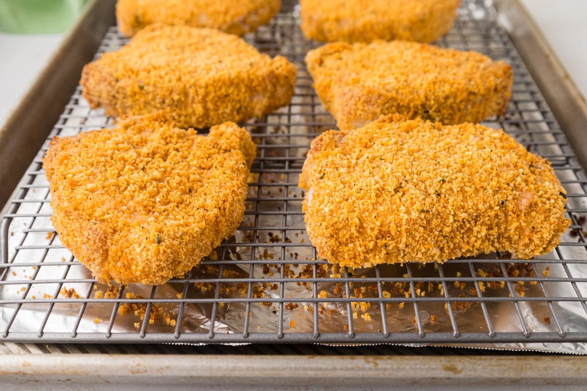 Cooked shake n bake pork chops on a baking rack on a baking sheet.