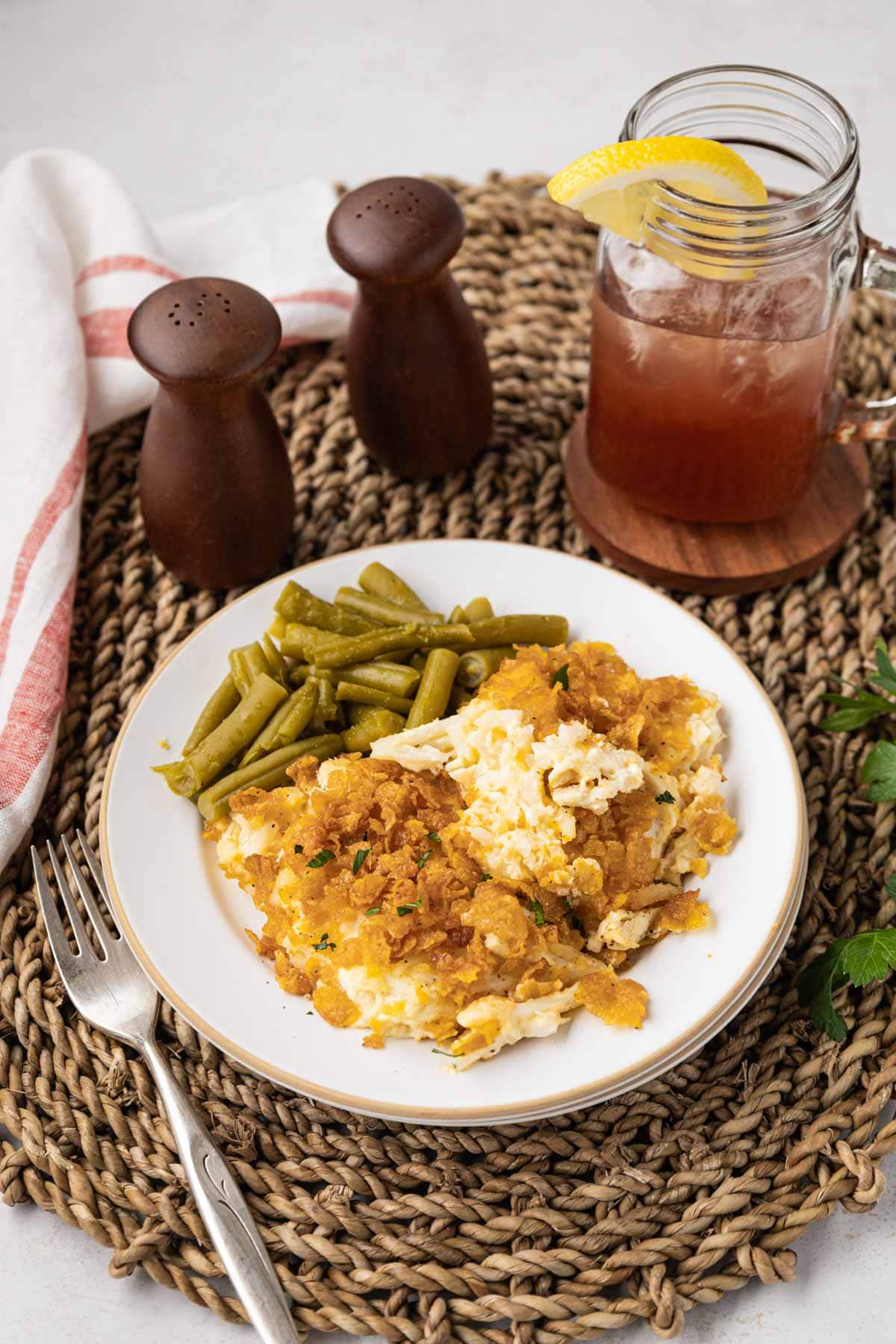 Chicken hash brown casserole served on a plate with green beans on the side.