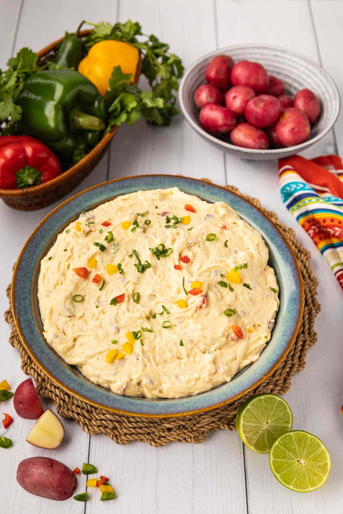A bowl of Mexican mashed potatoes with diced peppers on top.