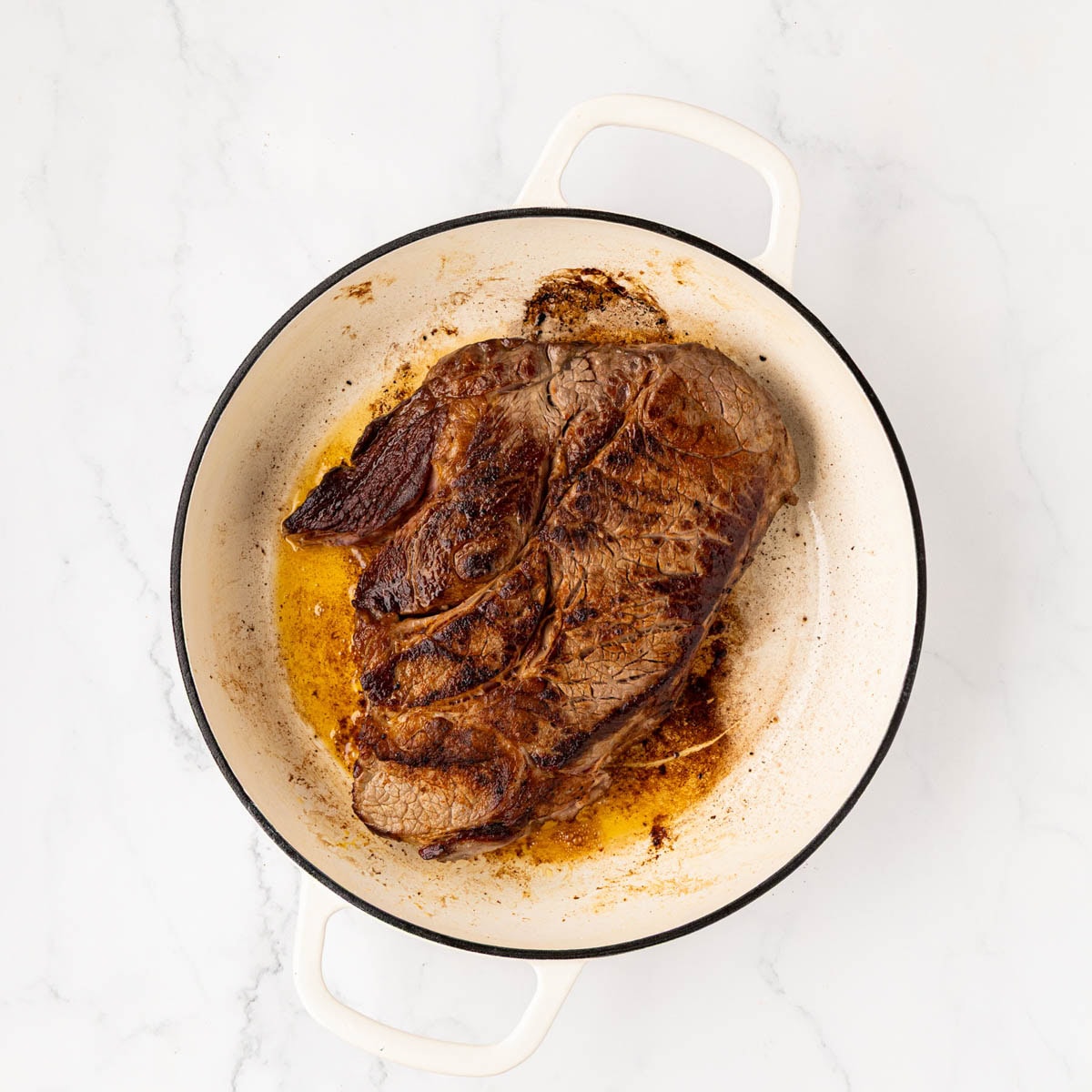 Pot roast searing in a Dutch oven pot.