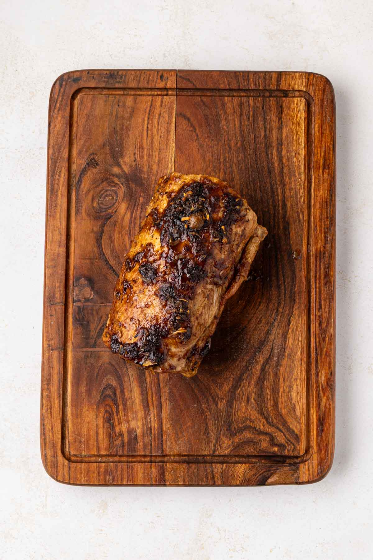 Pork loin roast on a wood cutting board.