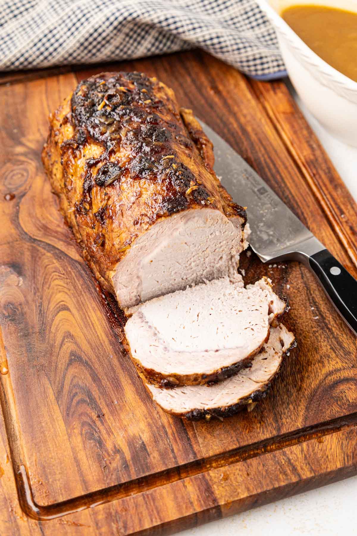 Pork loin roast sliced on cutting board.