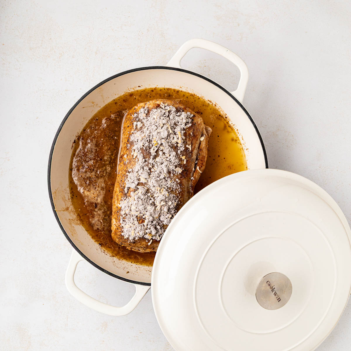 Placing the lid onto the pot to roast the pork.