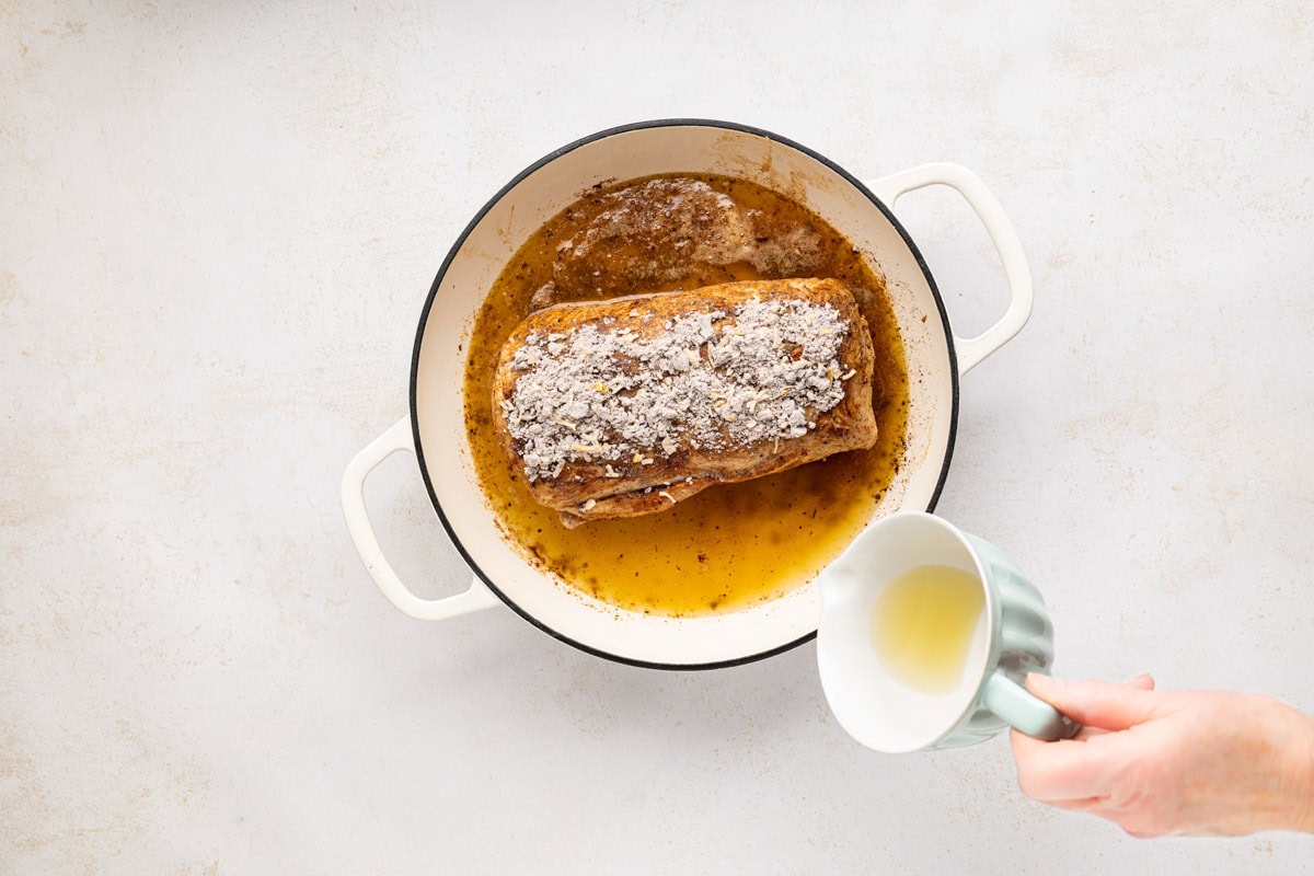 Onion soup mix and chicken broth poured onto the pork roast.