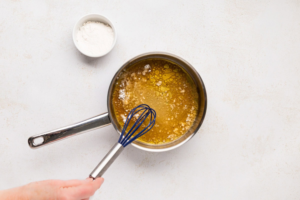 Whisking the flour with pork fat in a saucepan.
