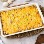 Baked hamburger hash brown casserole in a white baking dish.