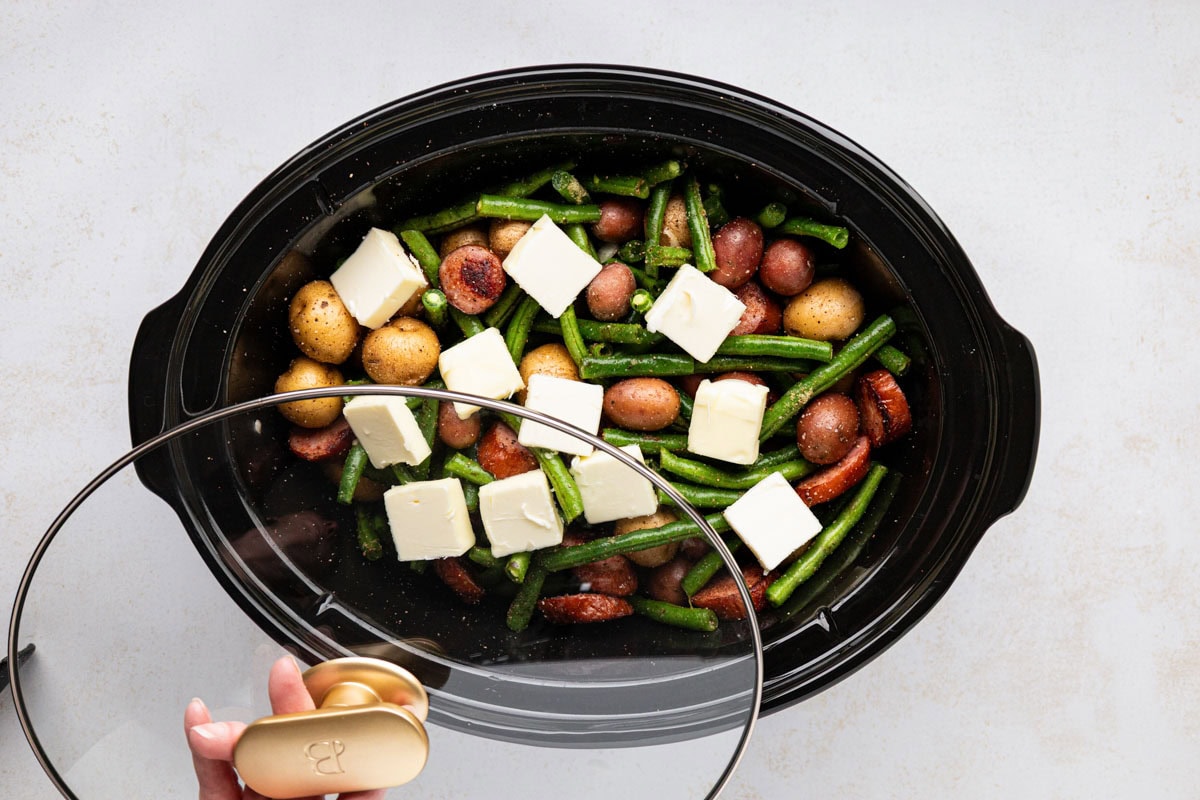Lid added on top of the slow cooker to cook.