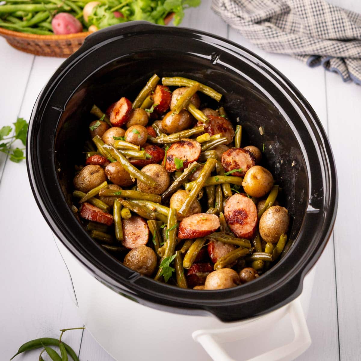 Finished swamp potatoes in a crock pot on a white background.
