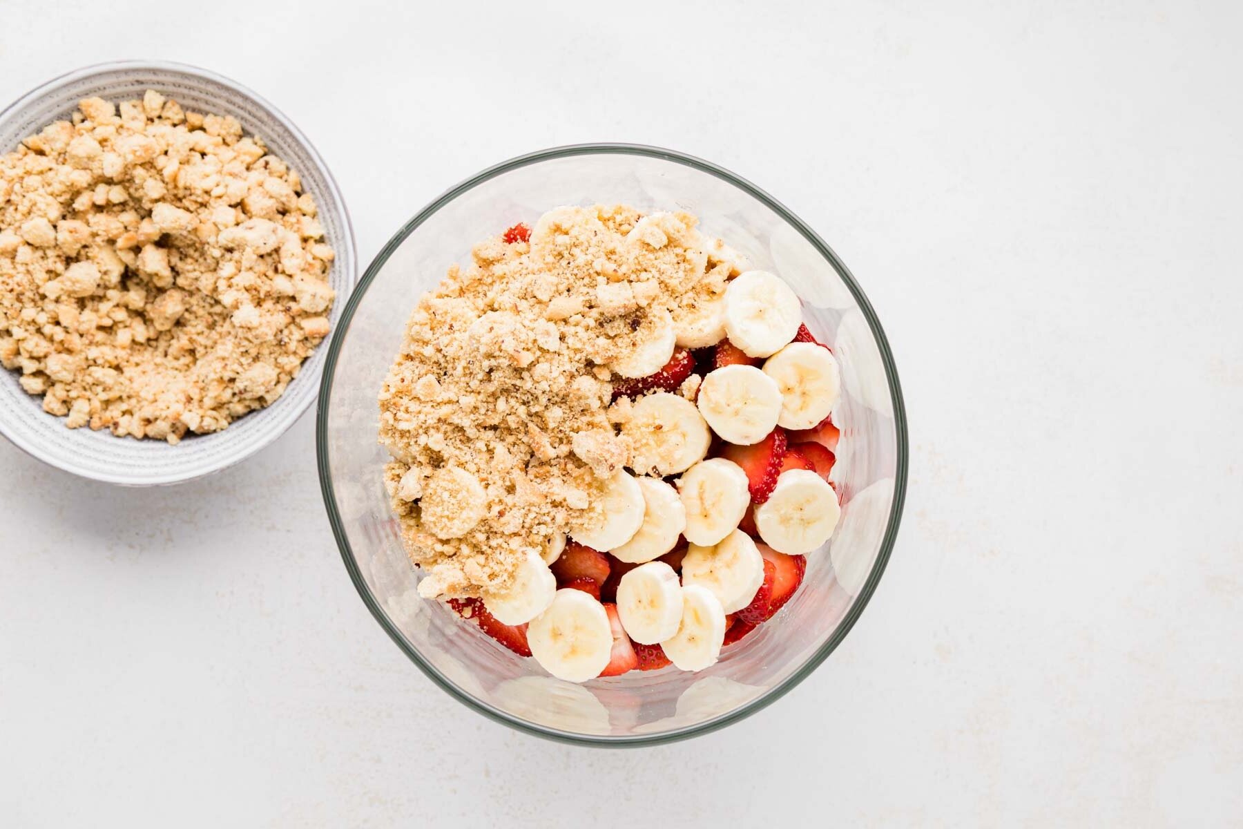 Crushed cookies on half of the sliced fruit layers showing some of the fruit to guide readers thru the process of layering the dessert.