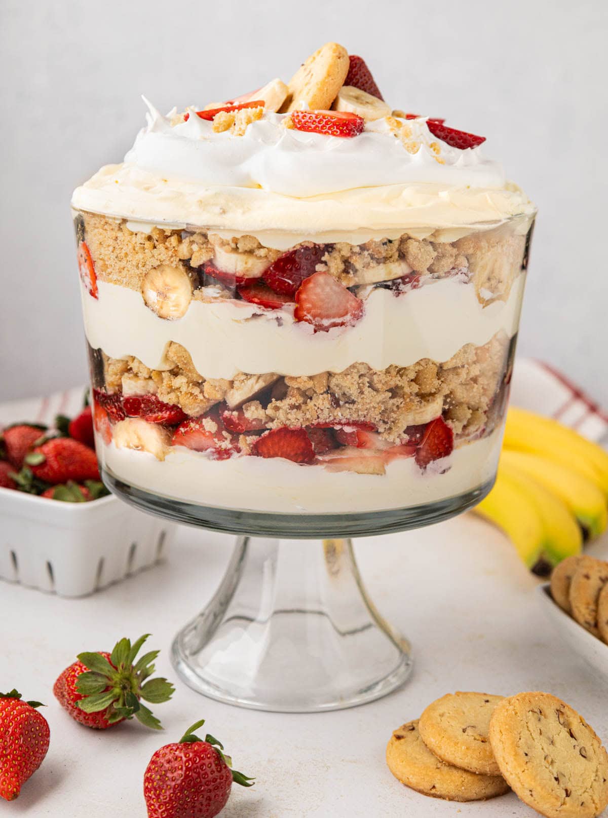 A clear trifle dish with layered strawberry banana pudding.