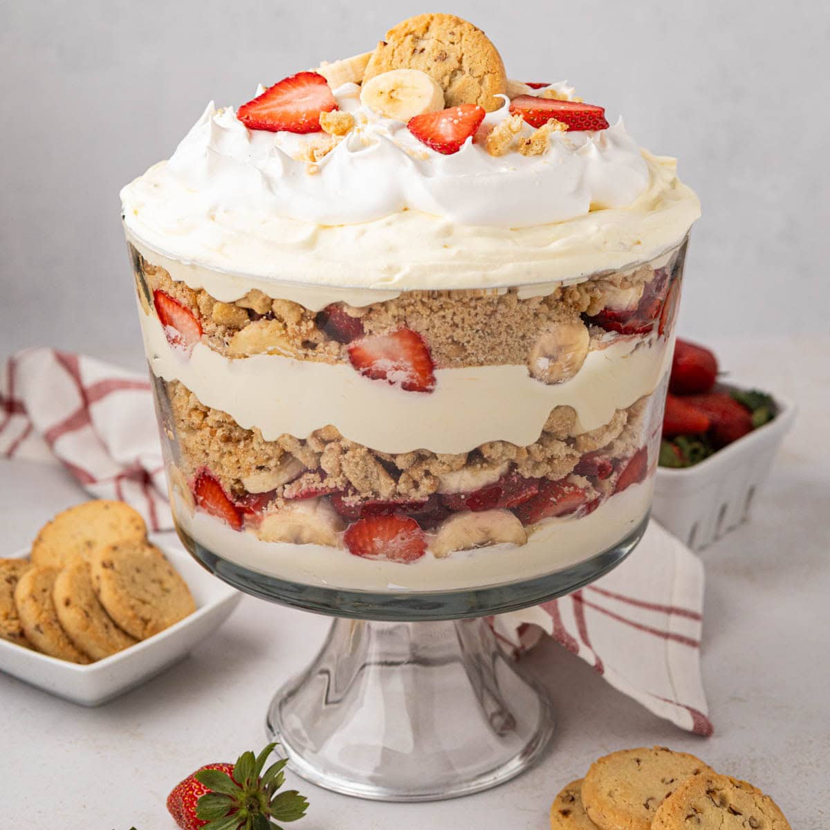 A clear trifle dish with layered strawberry banana pudding.