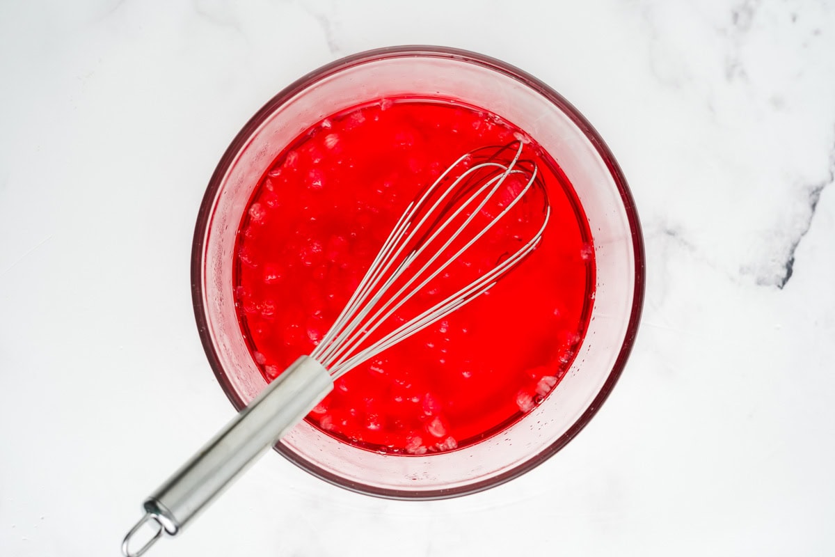 Ice water added to the strawberry jello mixture.