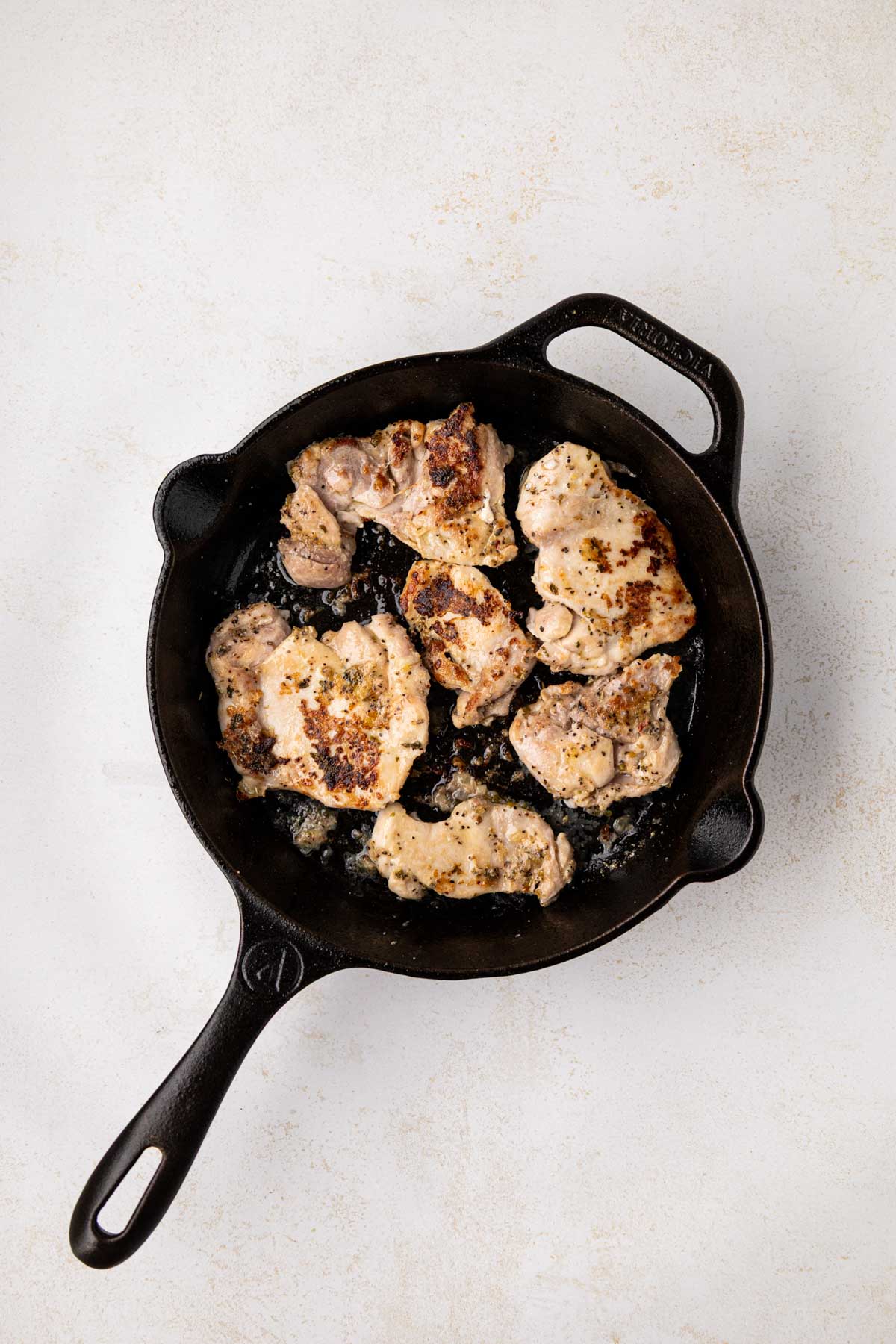 Pan cooked chicken in a cast iron skillet after seasoned and basted.