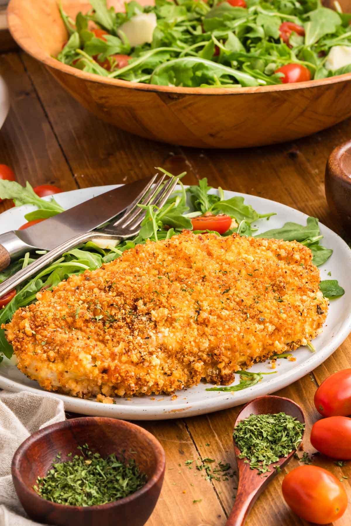 Air fryer chicken cutlet served on a plate with a side salad.