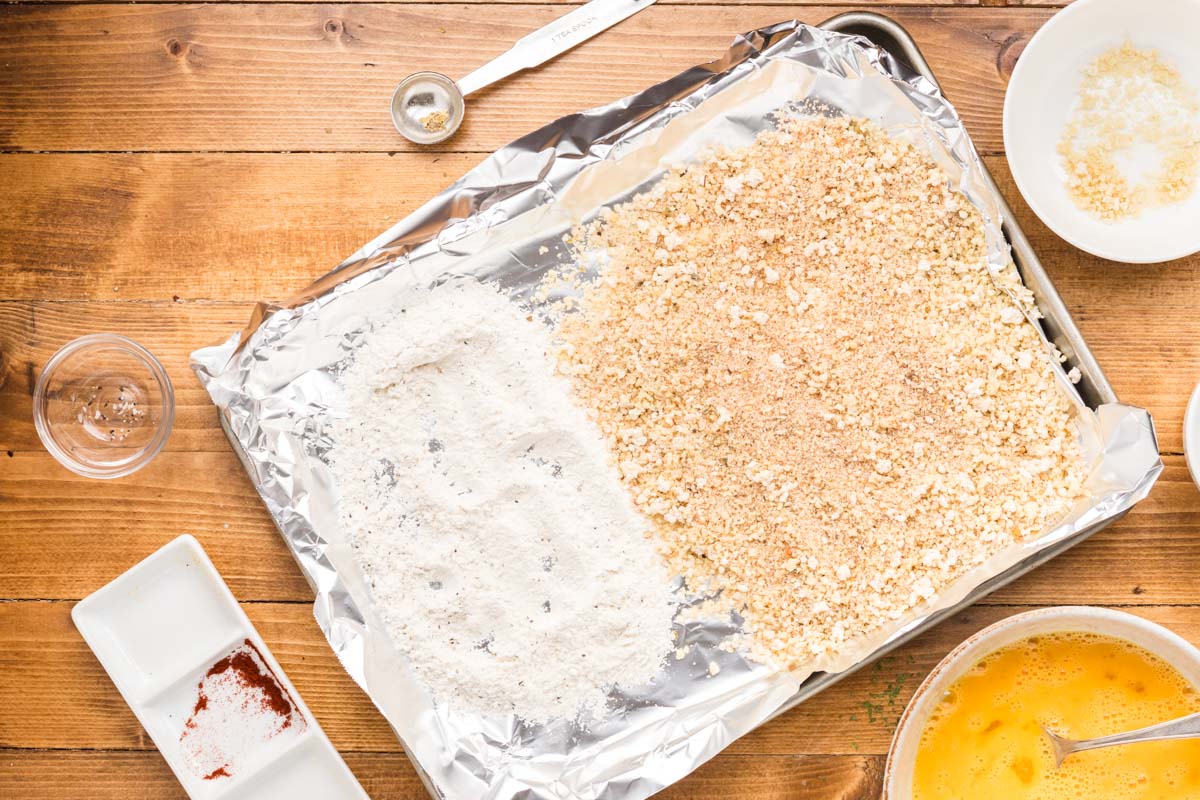 Breading station on a sheet pan with one half of flour and one half of seasoned panko breadcrumbs.