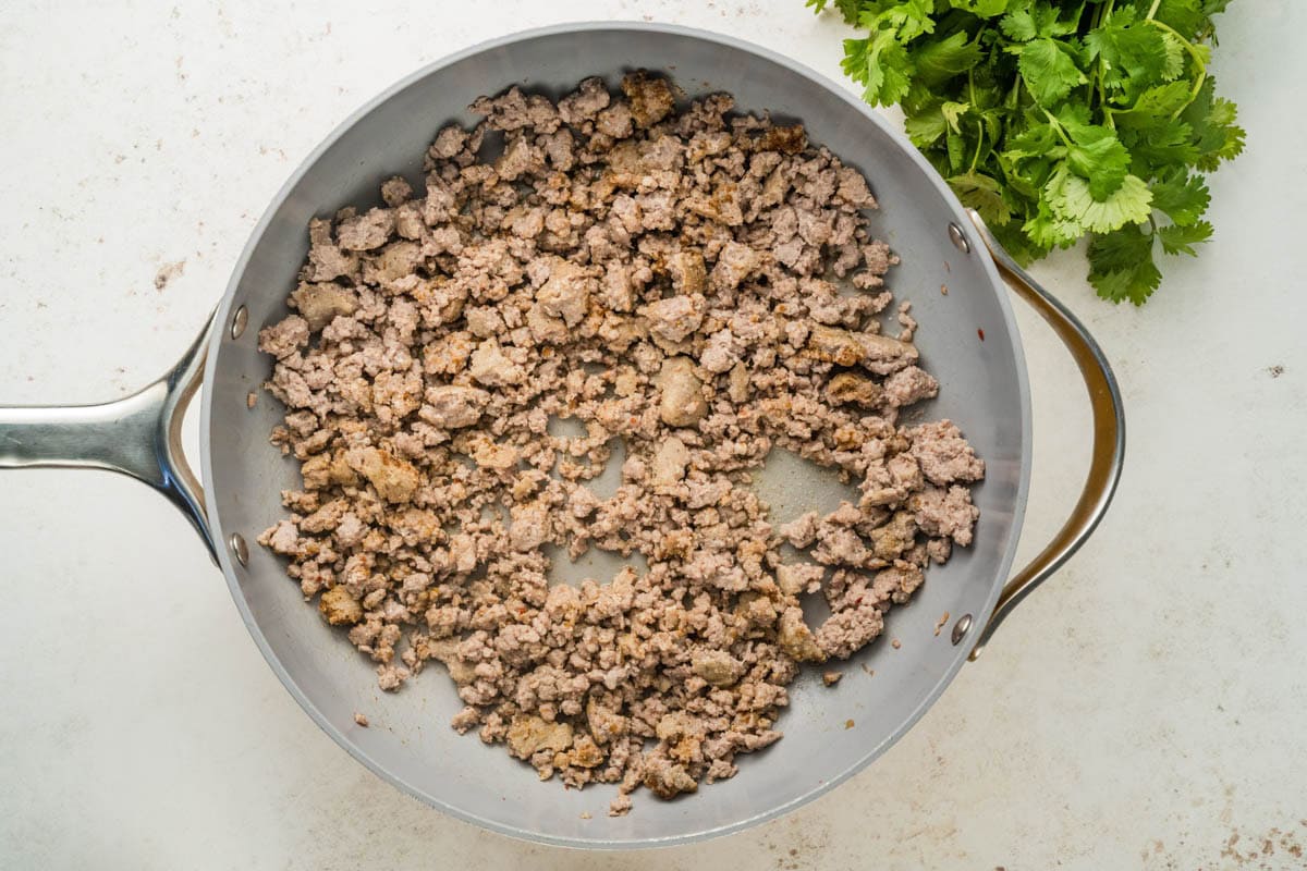 Browning ground sausage in a skillet.