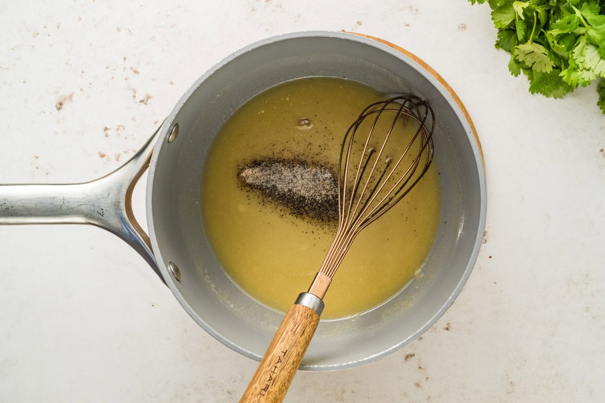 Seasoning the melted butter and flour mixture in a saucepan.