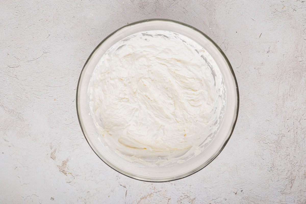 Cream cheese, powdered sugar and whipped topping mixed together in a bowl.