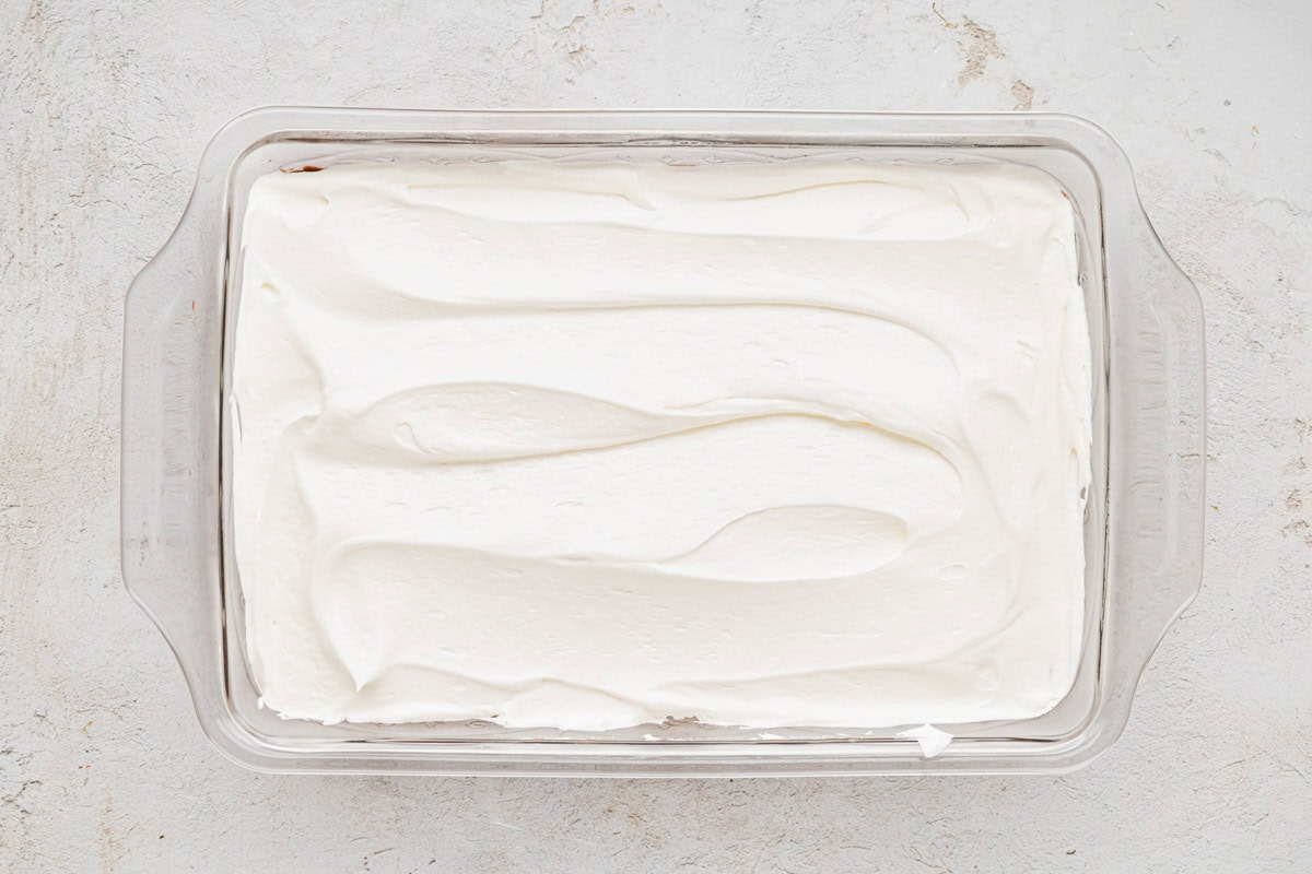 Whipped topping spread out evenly on top of the chocolate pudding layer.