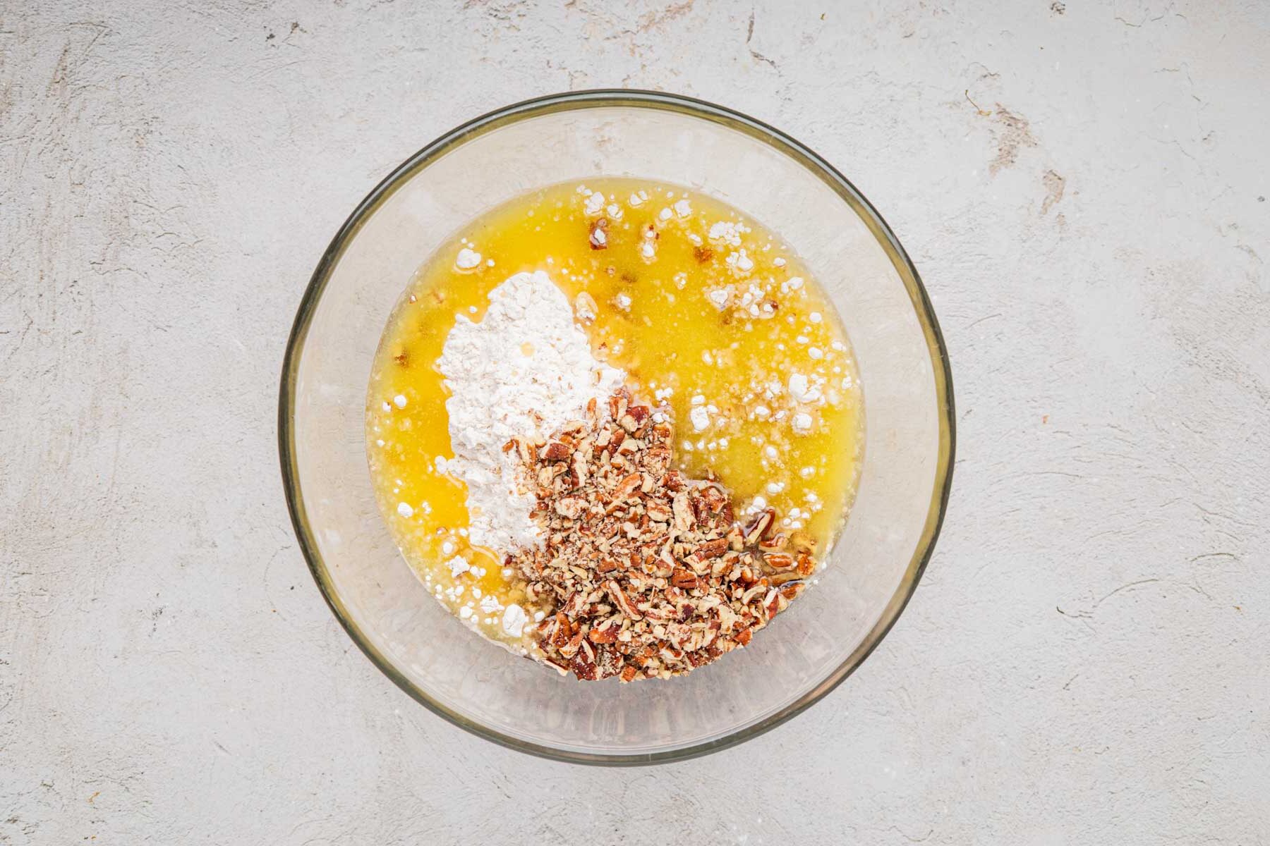 Flour, butter and nuts in a bowl.