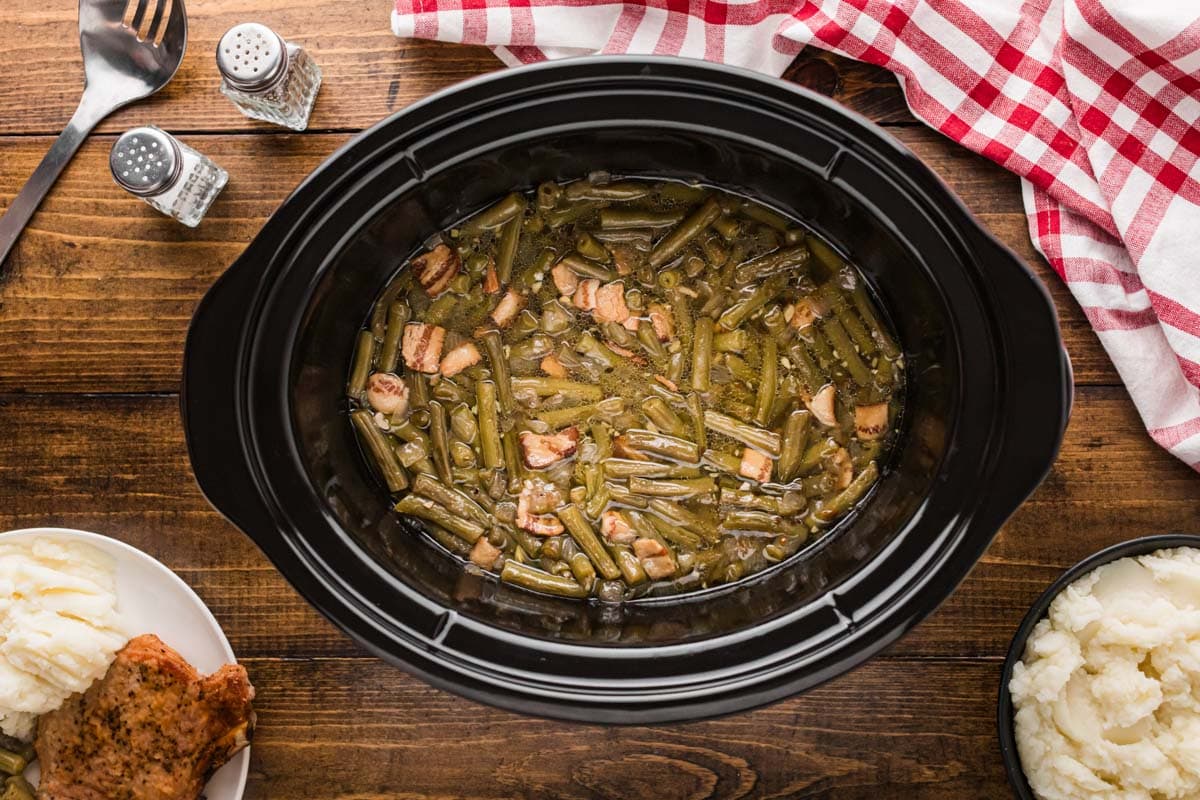 Cooked southern green beans in a slow cooker.