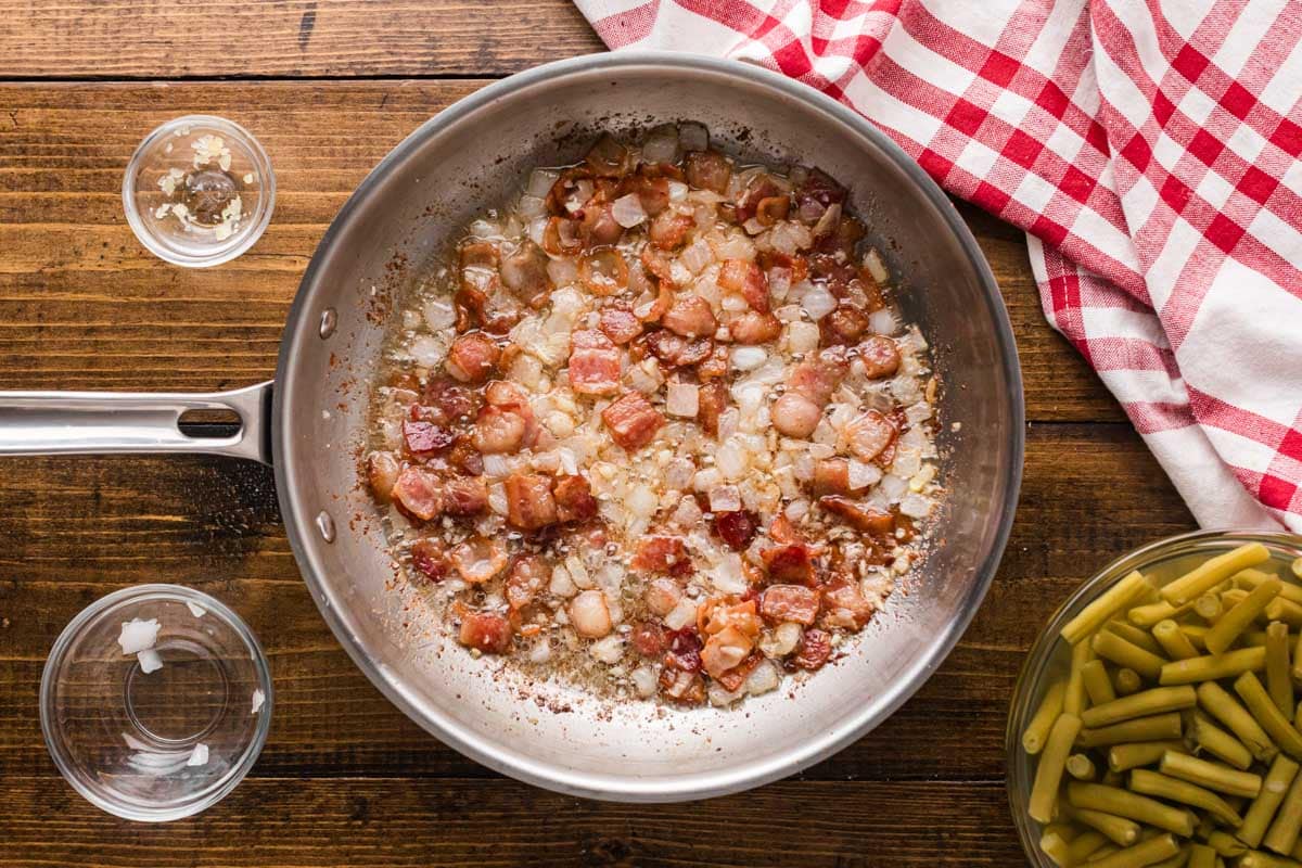 Diced onion and garlic added to the bacon in the skillet.