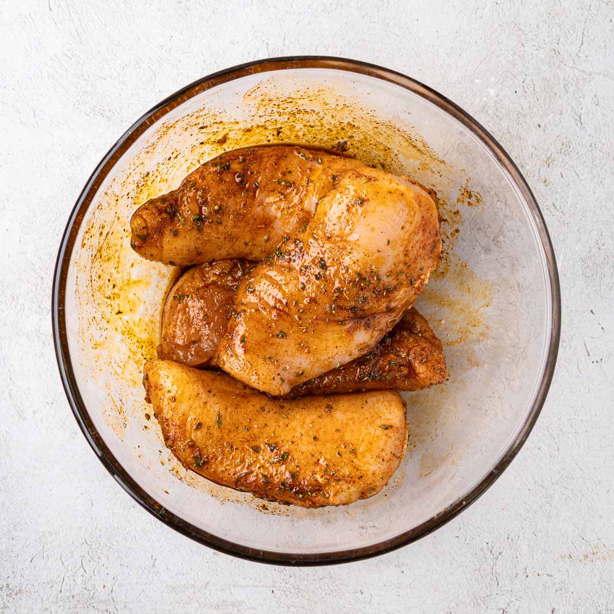Chicken after being tossed to completely coat with oil mixture.