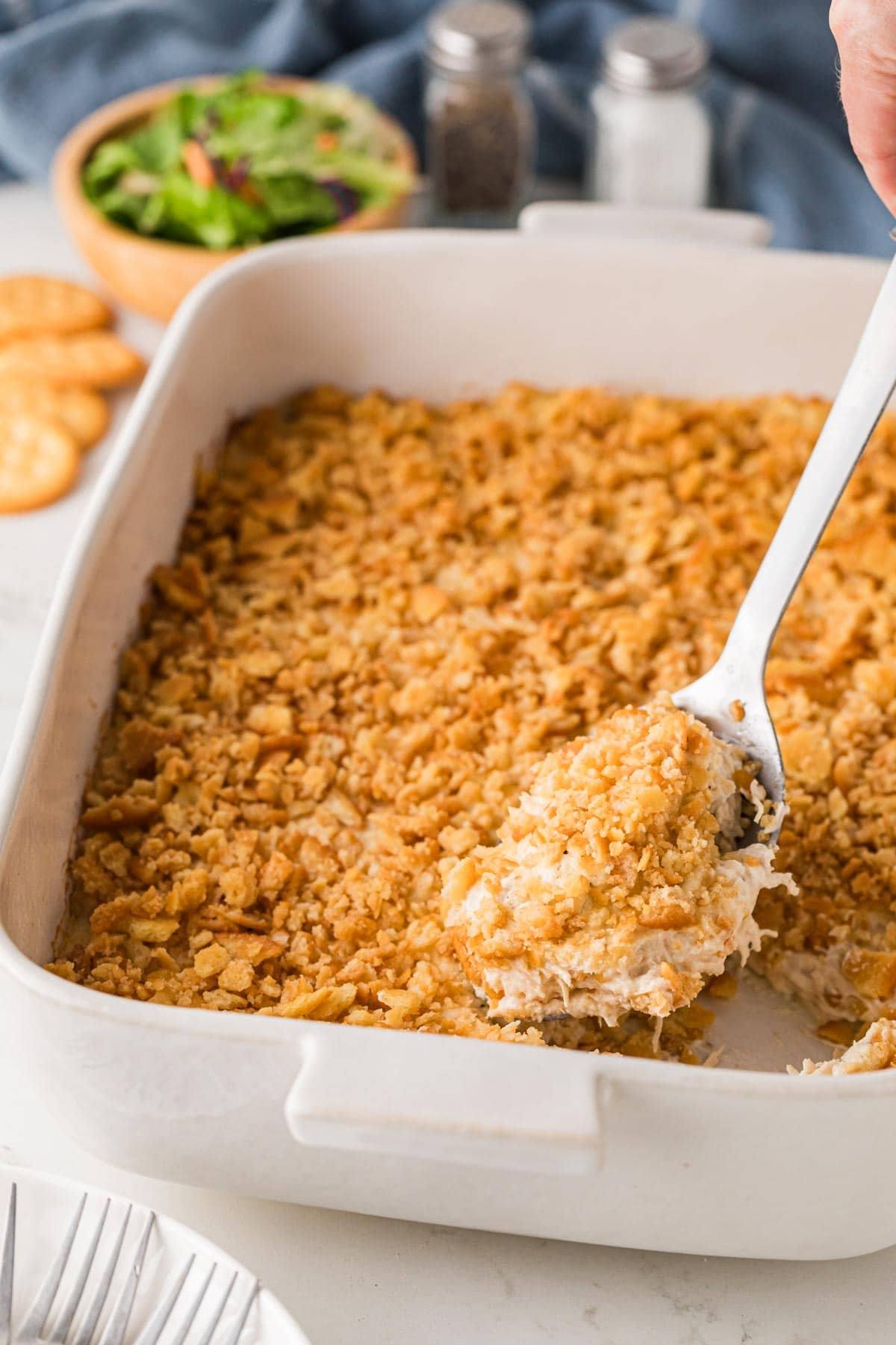 Serving spoon scooping up a portion of ritz cracker chicken casserole.