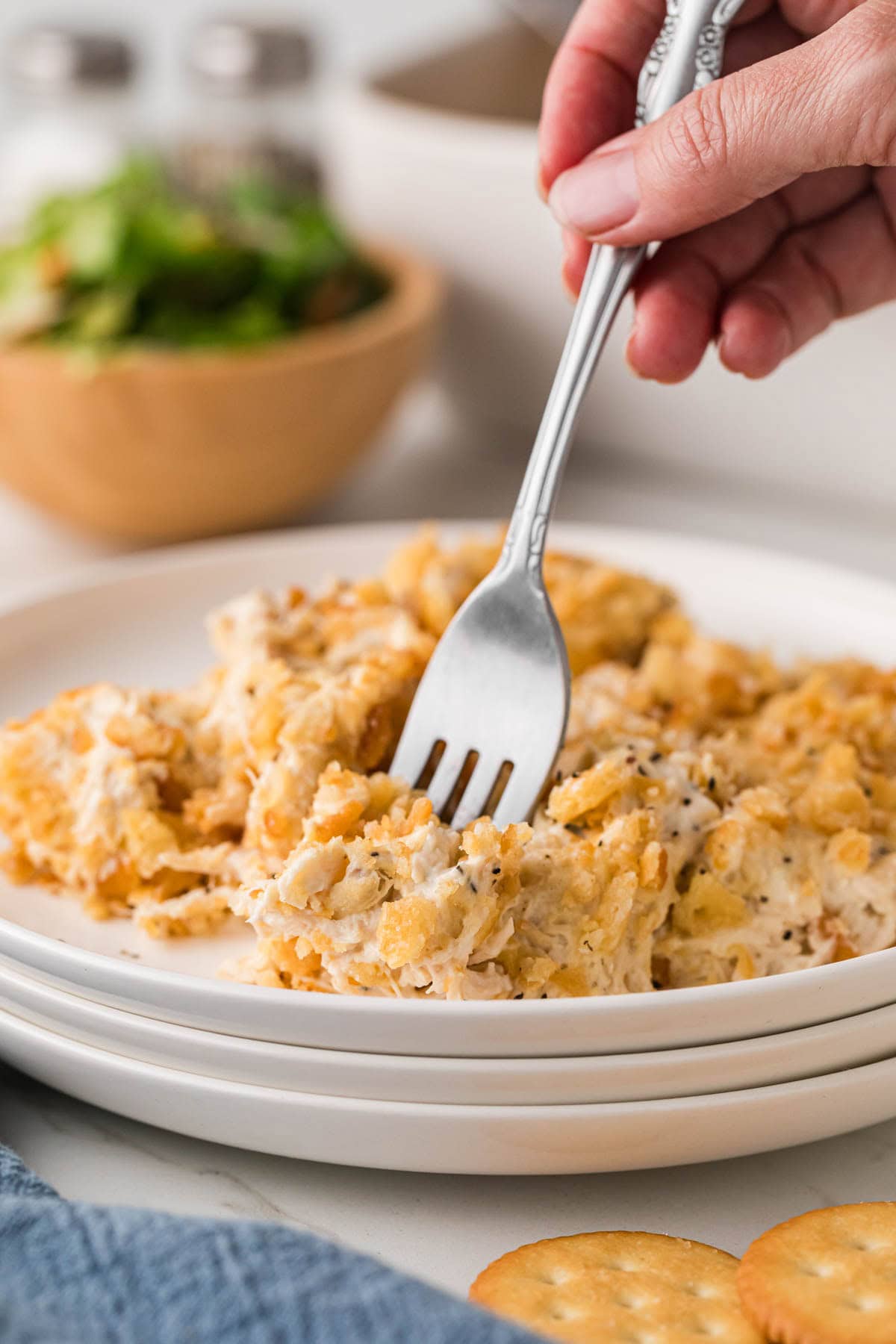 Fork taking a bite of Ritz cracker chicken casserole from a plate.