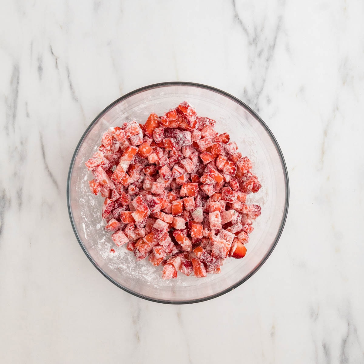 Flour and diced strawberries mixed in a bowl.
