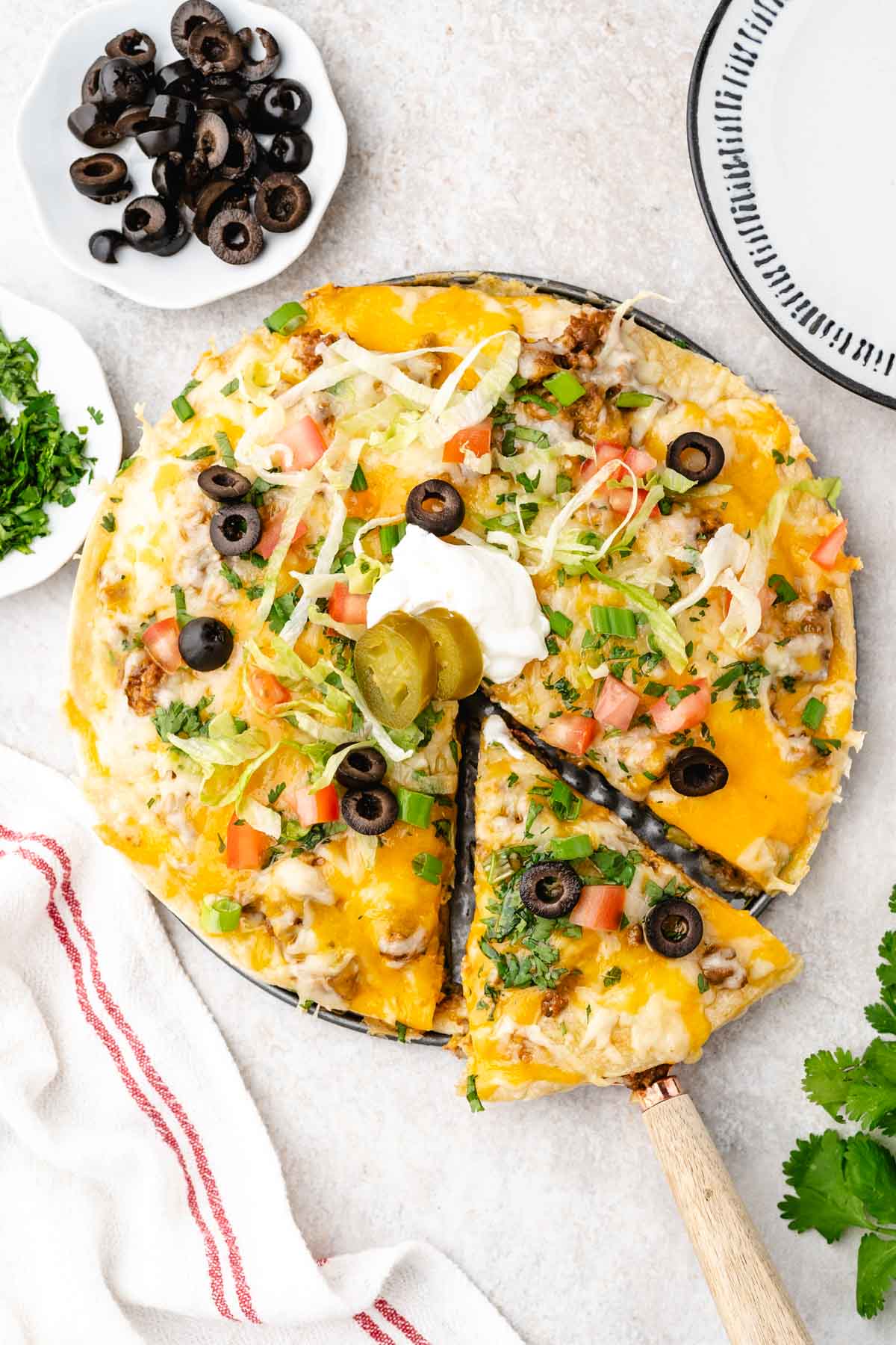 Taco casserole with tortillas on a plate with a spatula taking a slice.