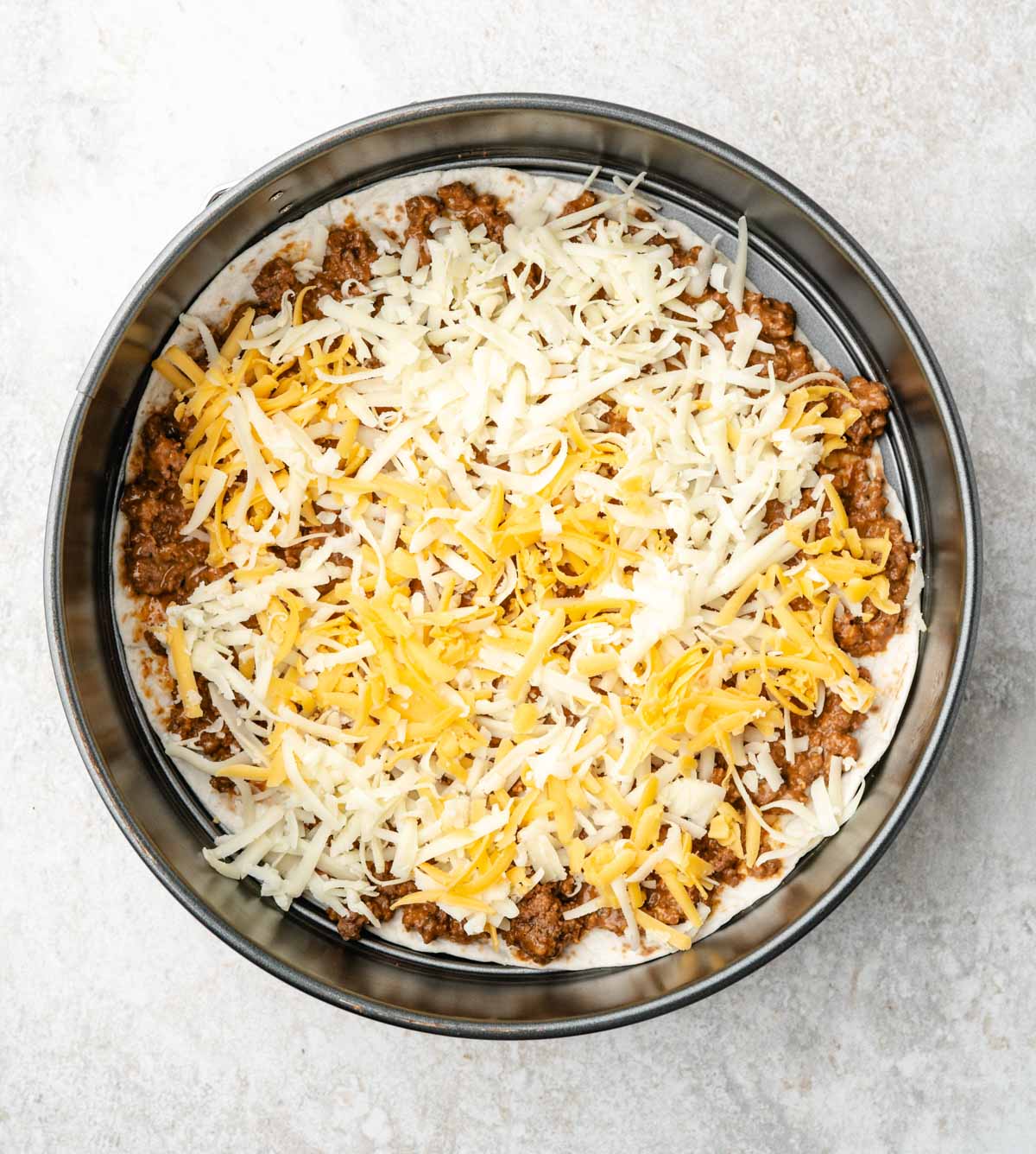 Cheese layered on top of the ground beef.
