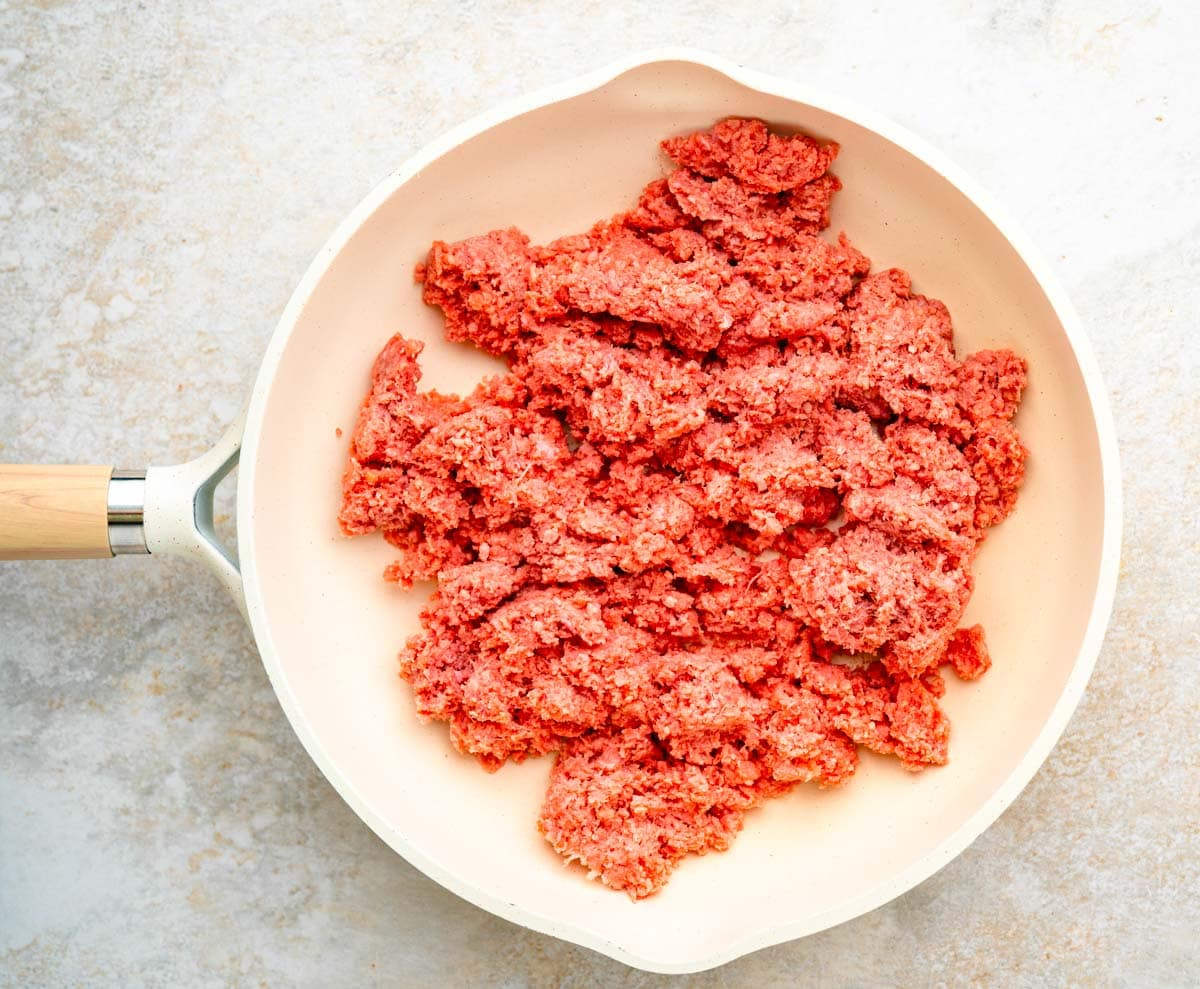 Ground beef in a skillet before browning.