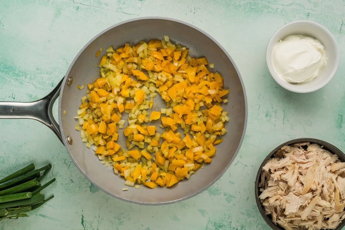 Bell pepper and onions cooking in a skillet.